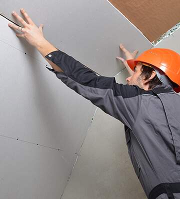 Construction worker laying drywall